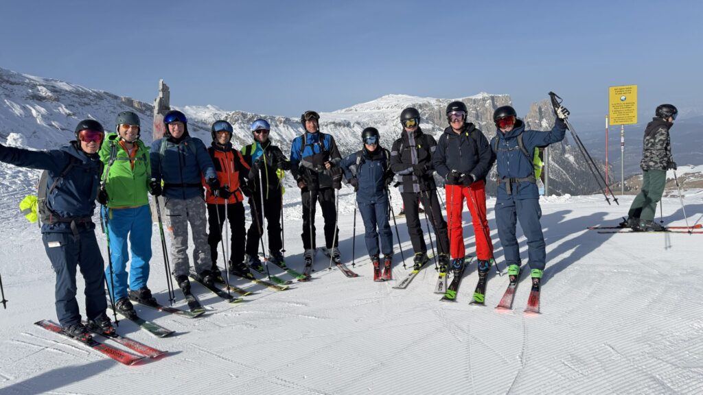 Groep skiërs poseert op de piste