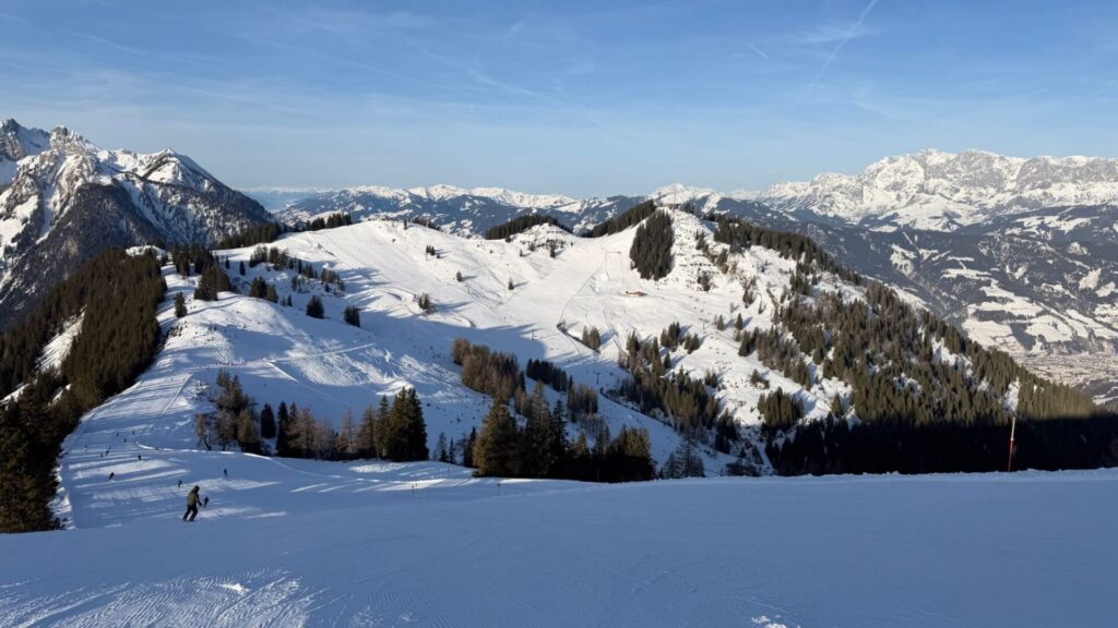 Lege pistes en uitgestrekte bergweides in de zon